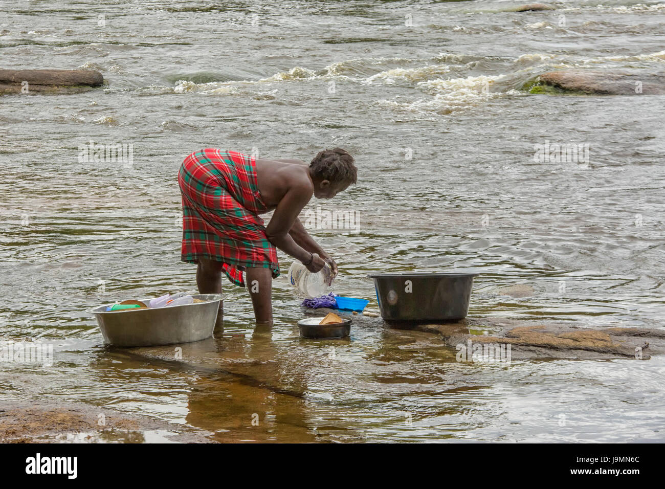 Frau, Reinigung von Geschirr in Fluß in der Nähe von ihrem Dorf im Regenwald in Suriname, Südamerika Stockfoto