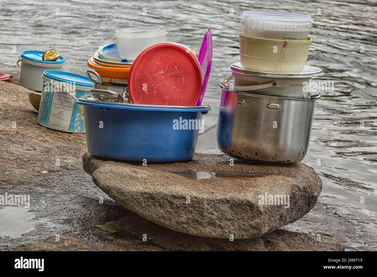 Stapel von gereinigt nur Kunststoffbehälter, Teller und Pfannen auf einem Felsen in der Nähe des Flusses Stockfoto