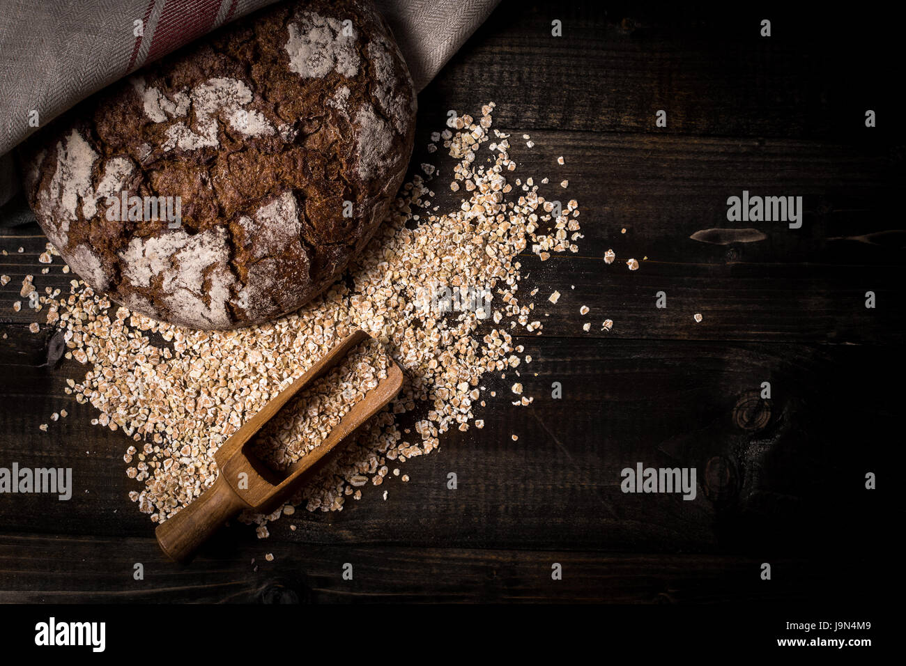 Traditionellen Vollkorn Roggenbrot auf dunklen Holztisch Hintergrund Stockfoto