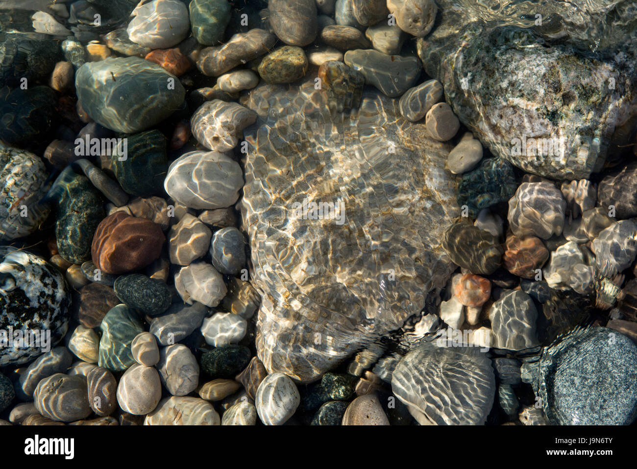 Wellen des kristallklaren Flachwasser Oberfläche, auf einem steinigen Strand des Lake Huron, Ontario, Kanada. Stockfoto