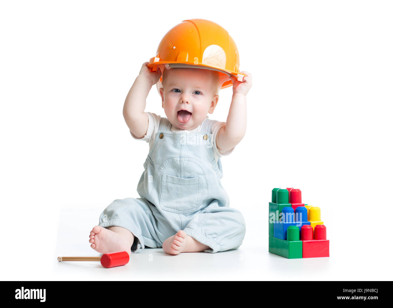 Baby in Bauarbeiterhelm spielen Spielzeug isoliert auf einem weißen Hintergrund. Stockfoto