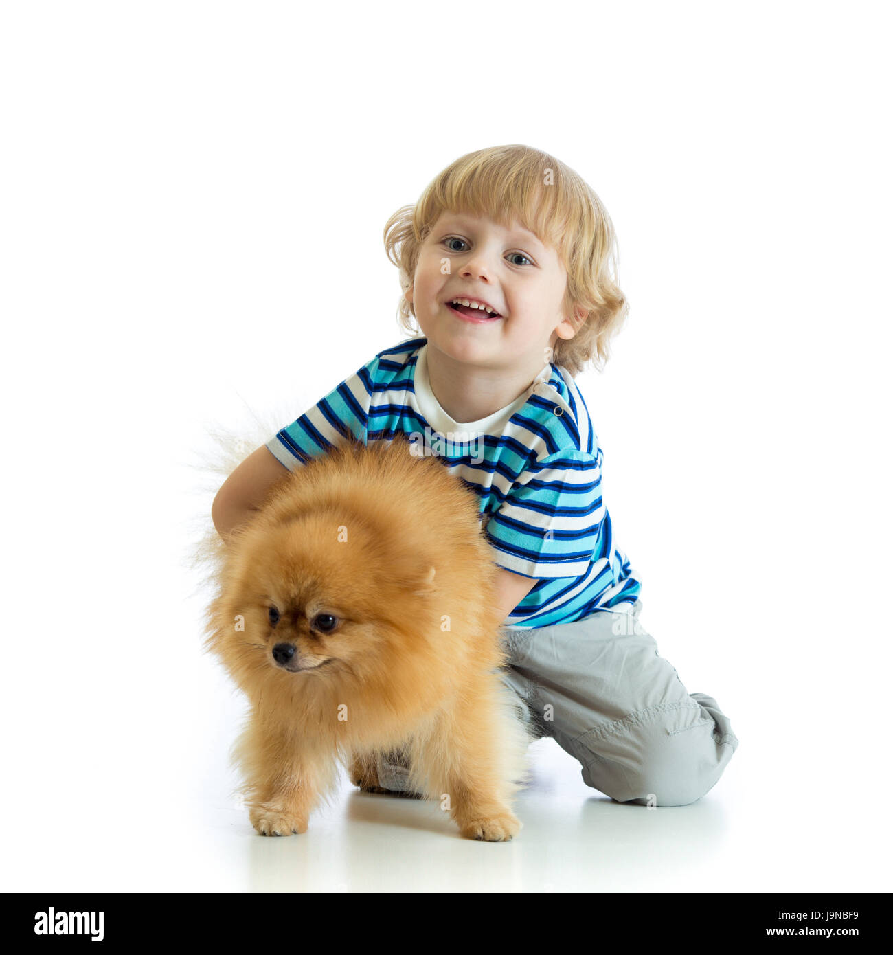 Kind Junge mit Hund Spitz, isoliert auf weißem Hintergrund Stockfoto