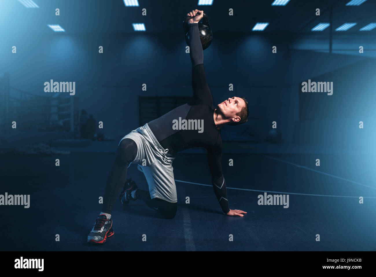 Sportlicher Mann auf training, Training mit Langhantel im Fitness-Studio. Aktive Übungen im Sportclub Stockfoto