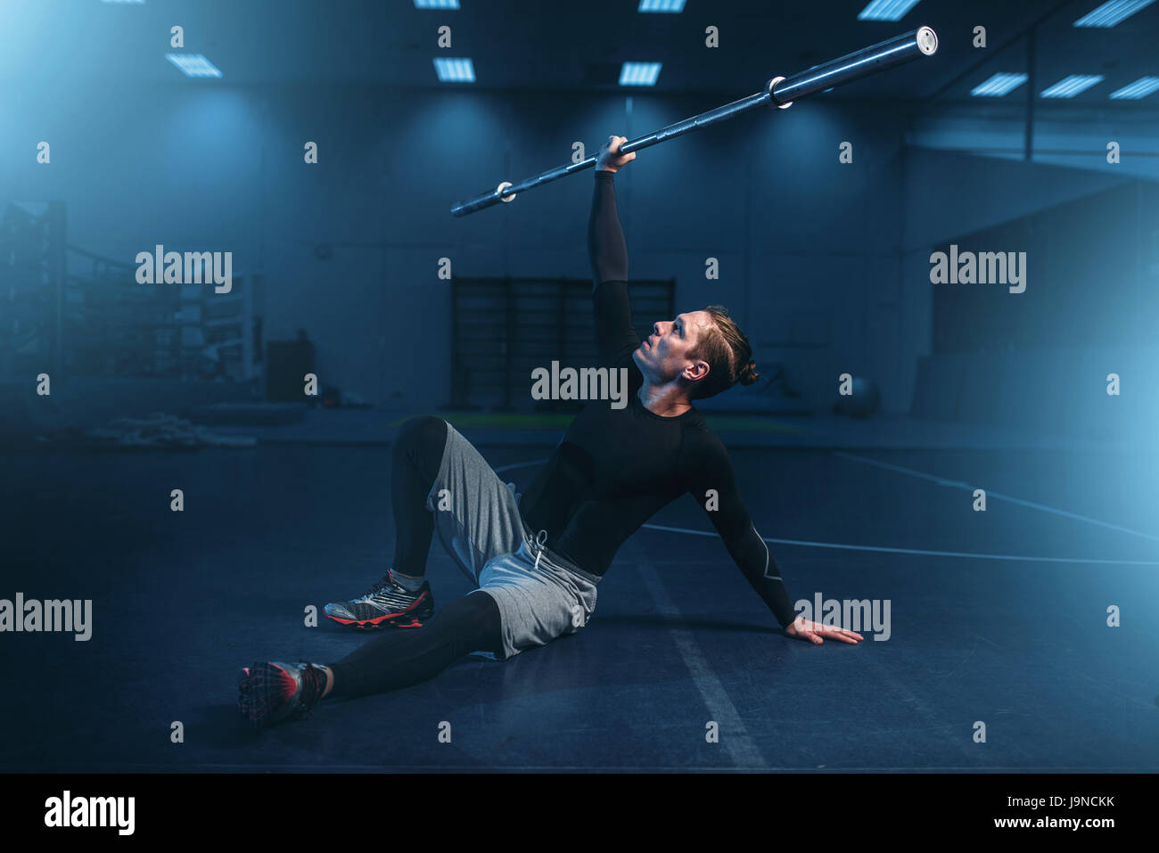 Sportlicher Mann auf training, Training mit Langhantel im Fitness-Studio. Aktive Übungen im Sportclub Stockfoto