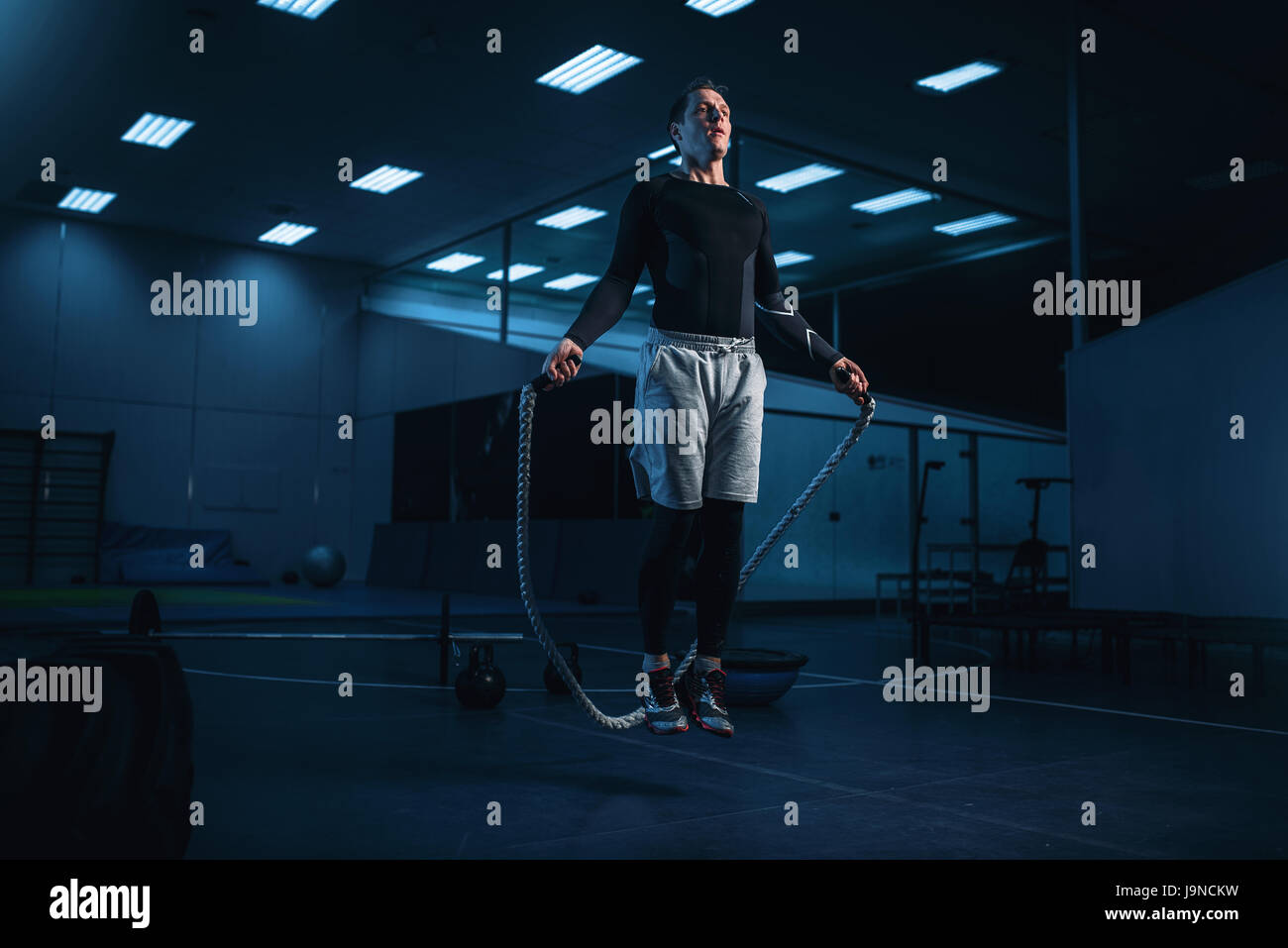 Aktiven Mann auf training, Training mit Seil im Fitness-Studio. Energieübungen im Sportclub Stockfoto