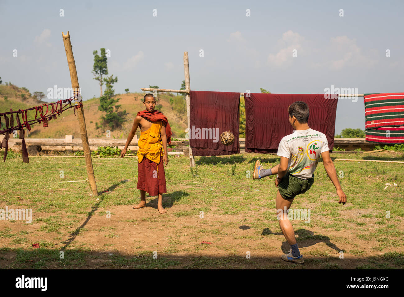 Junge Männer, die einen geflochtenen Ball in einem kleinen Dorf in der Nähe von Inle-See, Myanmar. Stockfoto