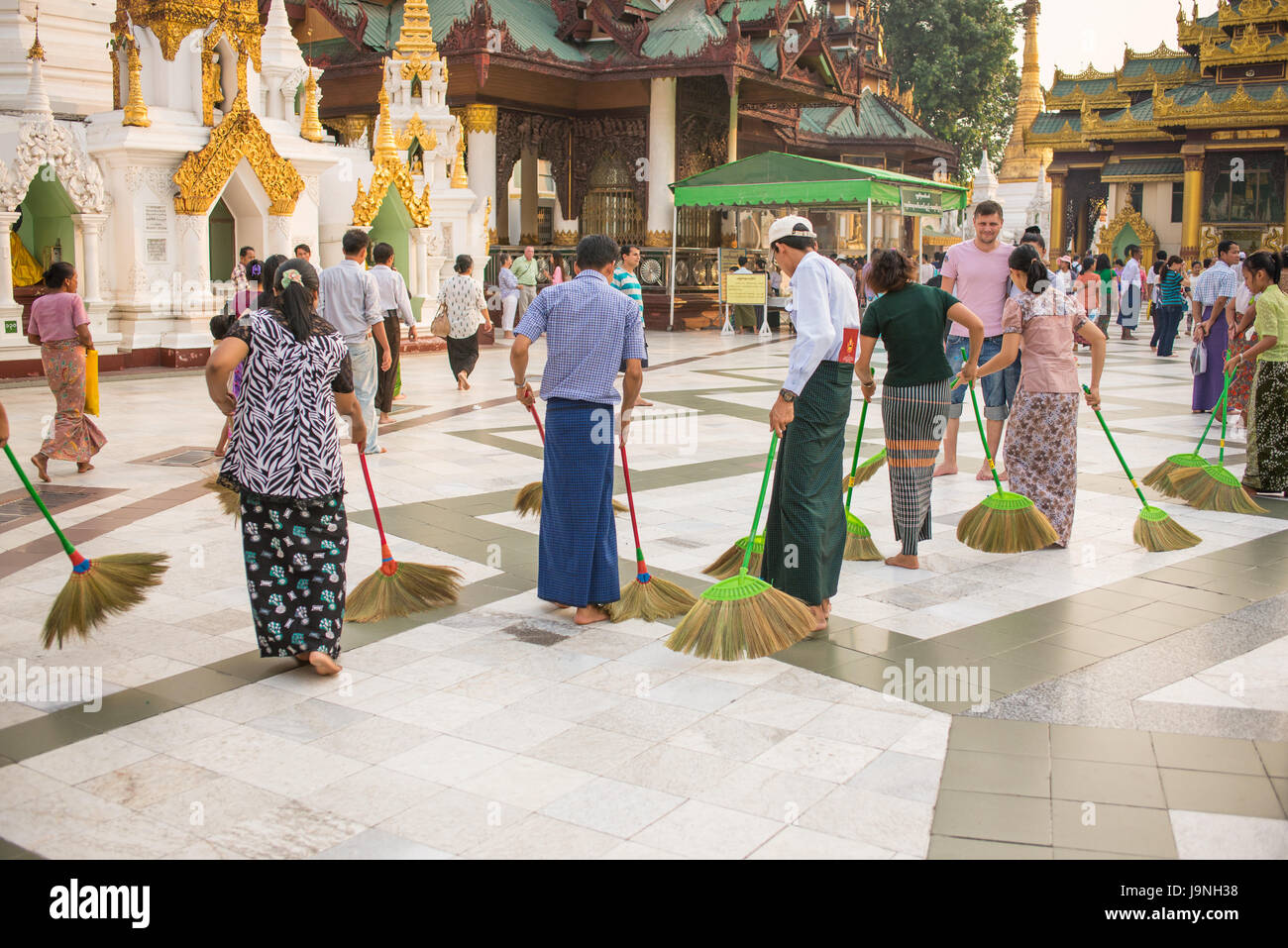 Reinigung des Bodens mit der weichsten Besen aller Zeiten. Shwedagon-Pagode, Yangon, Myanmar. Stockfoto