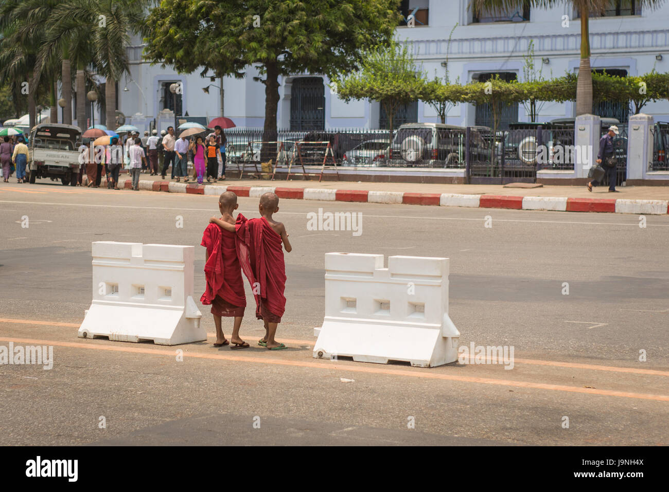 Zwei junge Mönche zusammen die Straße überqueren. Yangon, Myanmar. Stockfoto