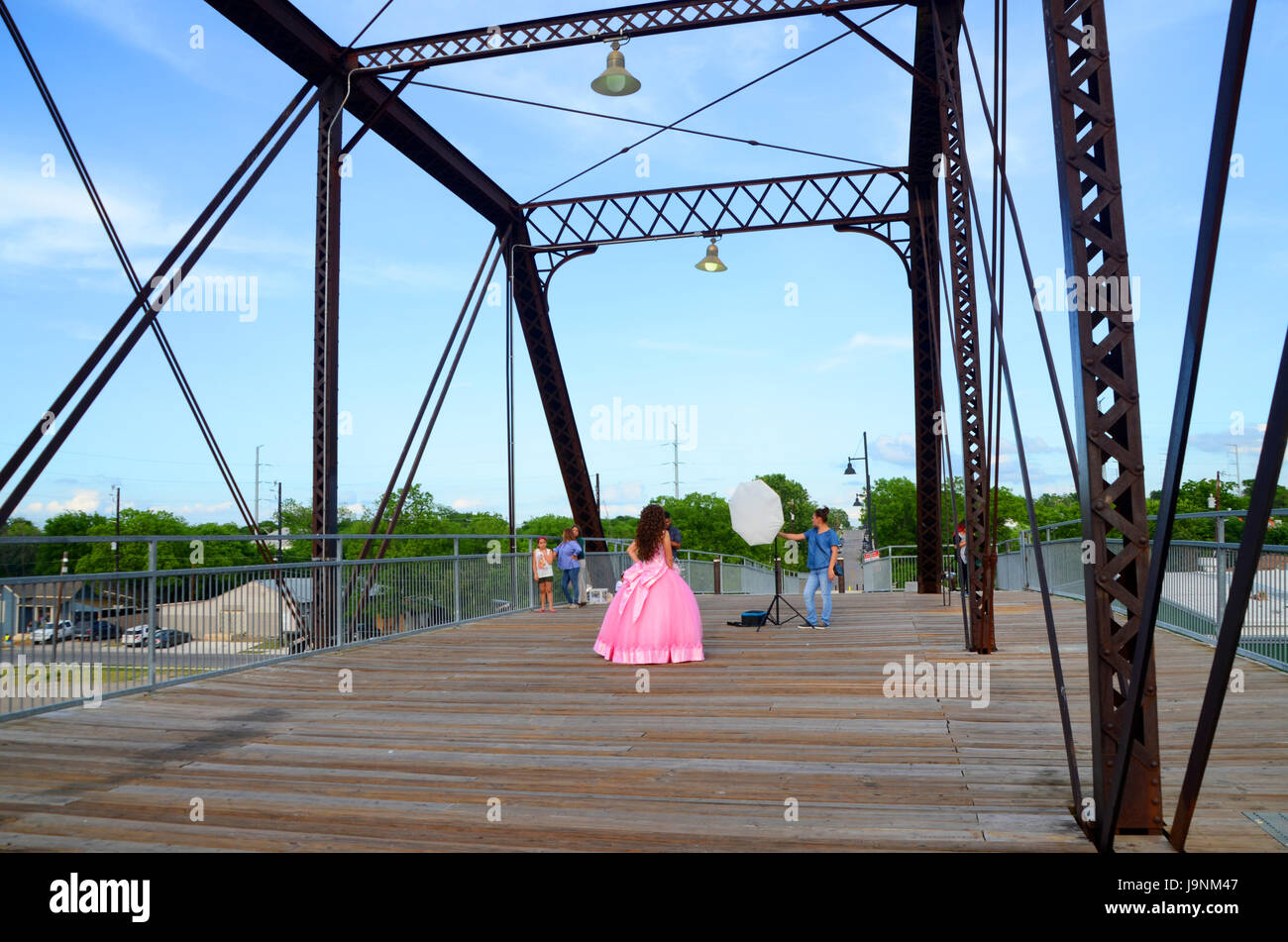 Ein Fotograf Fotos ein Mädchen in einem rosa Kleid in San antonio Texas auf einer Eisenbahnbrücke Stockfoto
