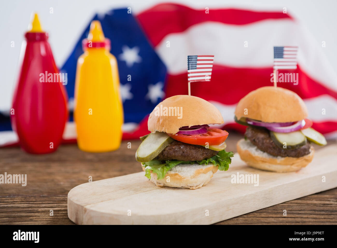 Burger auf Holzbrett mit 4. Juli Thema angeordnet Stockfoto