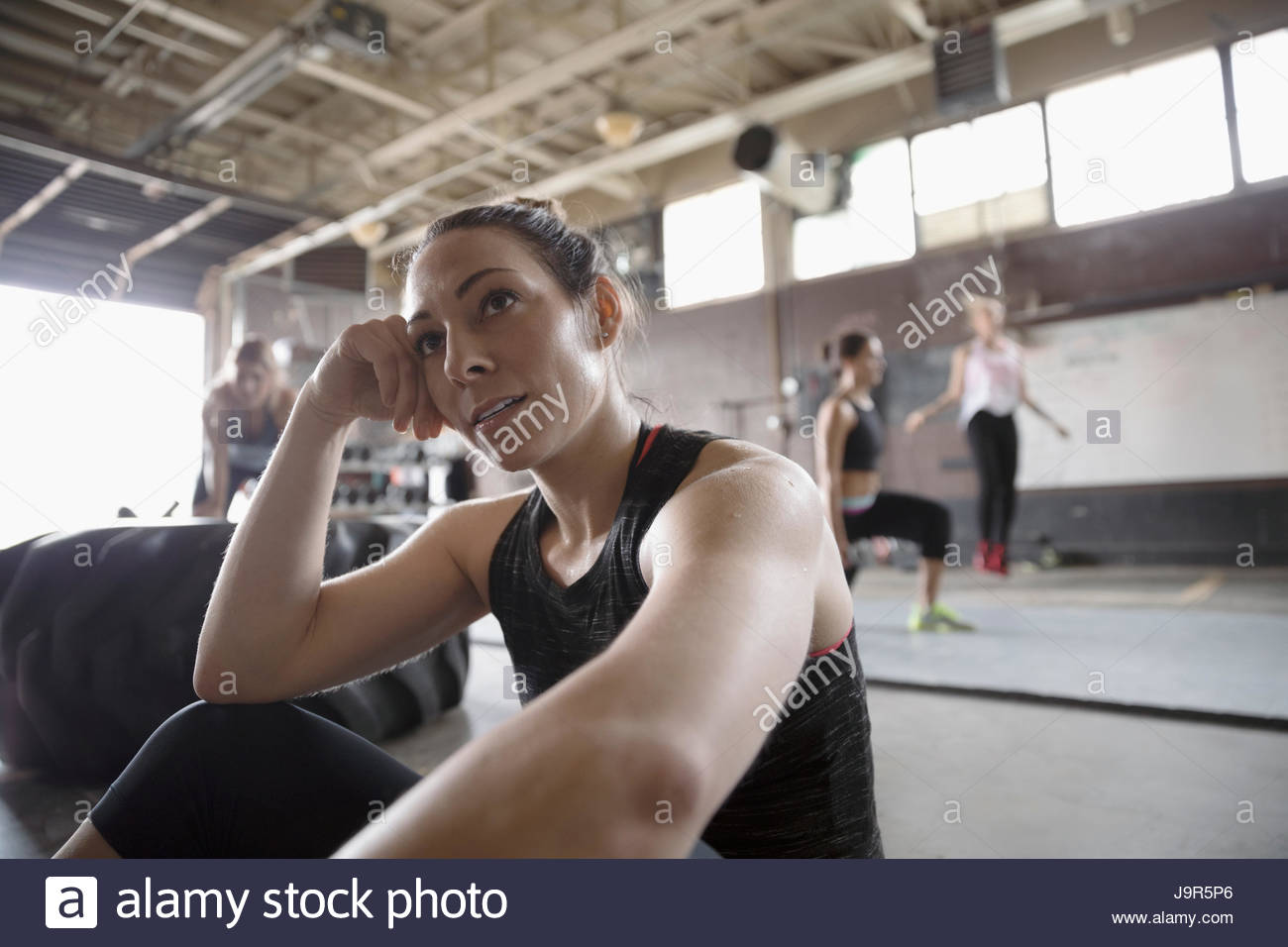 Starke Frau ruht in düstere Turnhalle Stockfoto