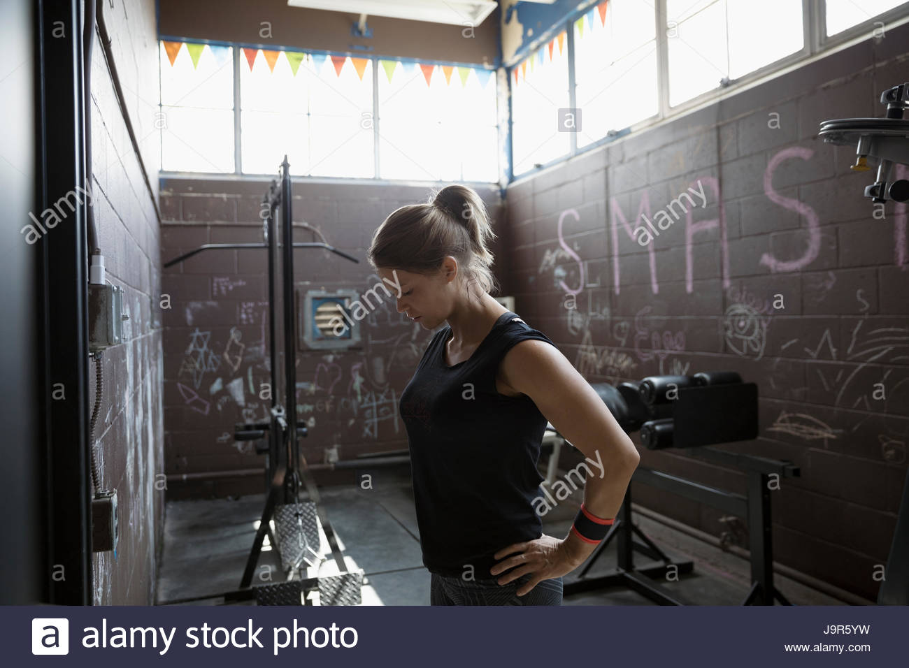 Fit Woman Gewichtheben in düstere Turnhalle Stockfoto