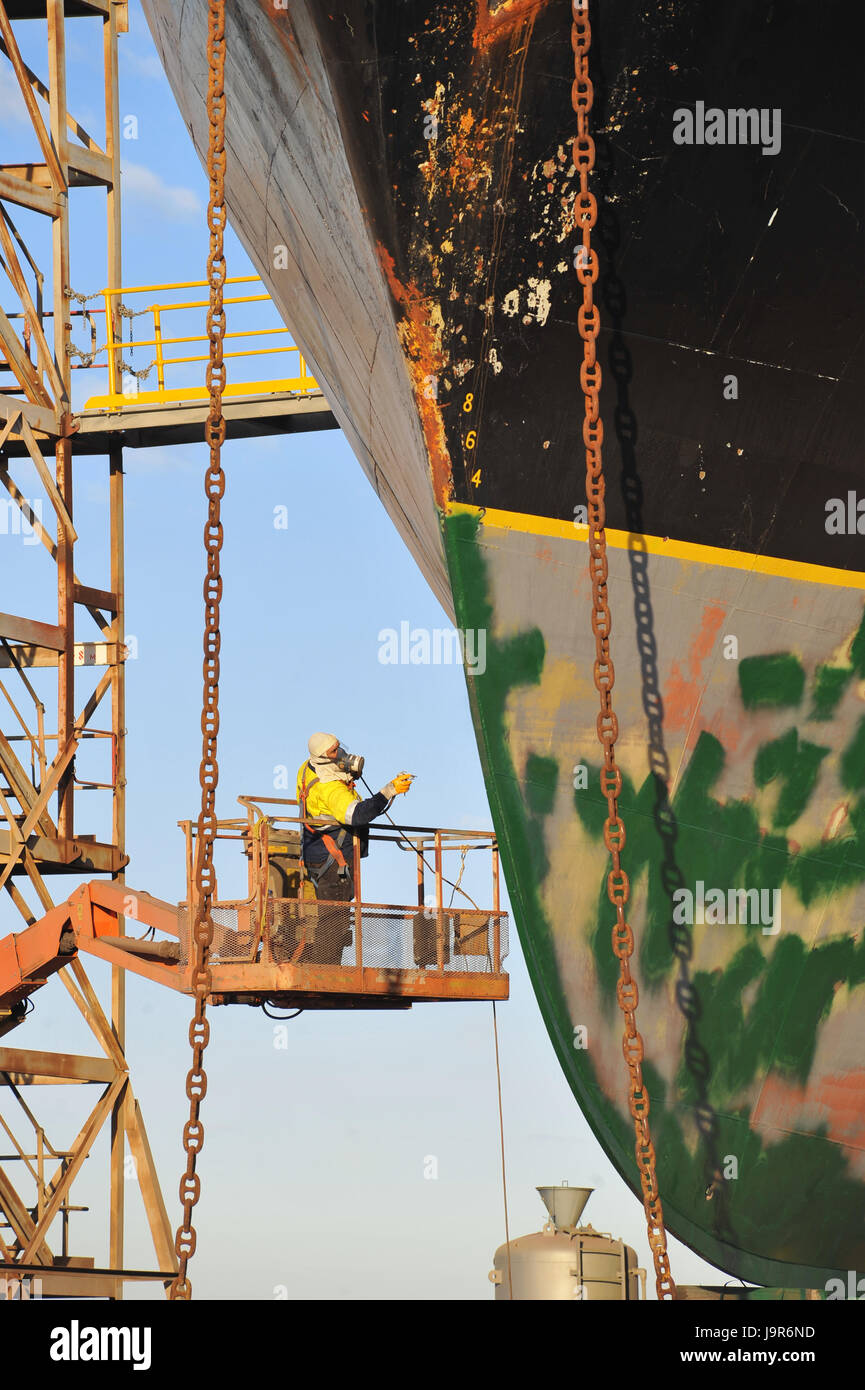 Ein Porträt der marine Techniker an einem Gantry, Malerei der Kiel eines Schiffes auf Slipway. Stockfoto