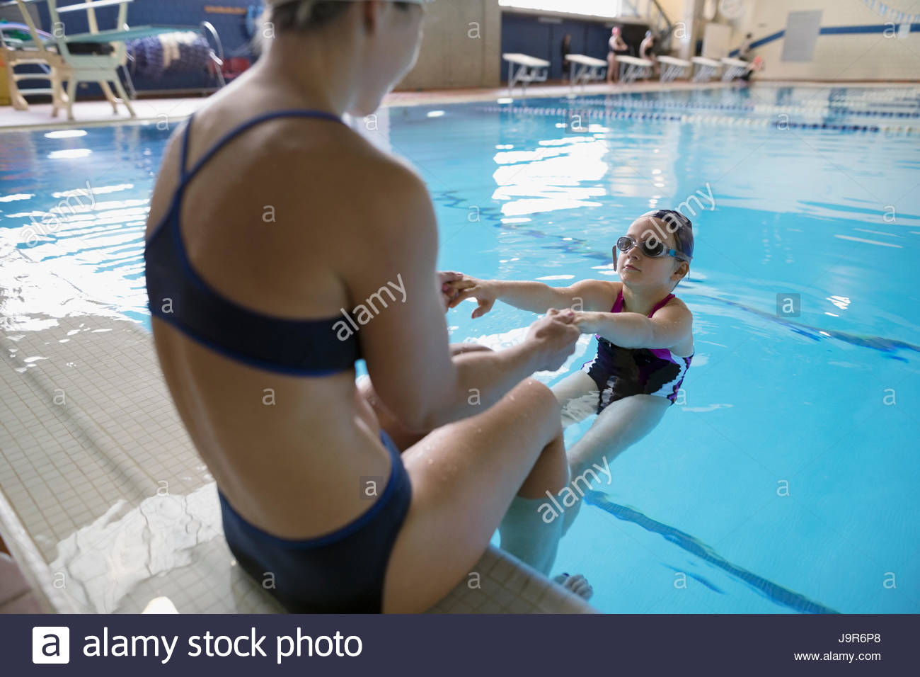 Mutter coaching Tochter Schwimmen im Schwimmbad Stockfoto