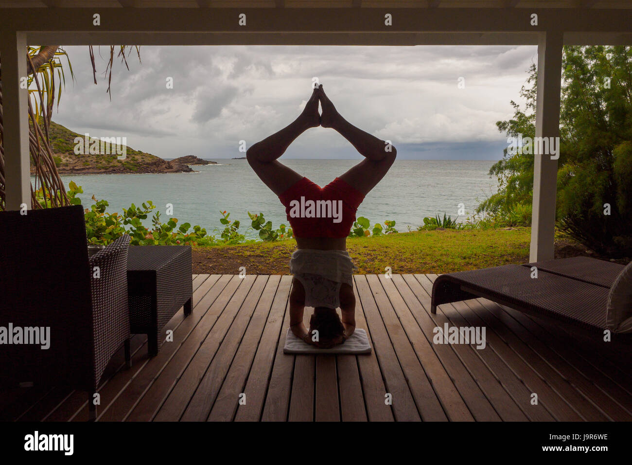 Yoga-Kopfstand mit Blick auf das Karibische Meer auf der Insel St. Barth, St. Bartholomy, St. Barts, in den französischen Antillen Stockfoto