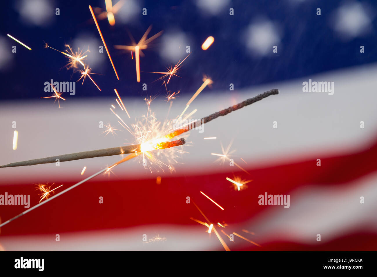 Nahaufnahme von Wunderkerzen brennen gegen amerikanische Flagge Hintergrund Stockfoto