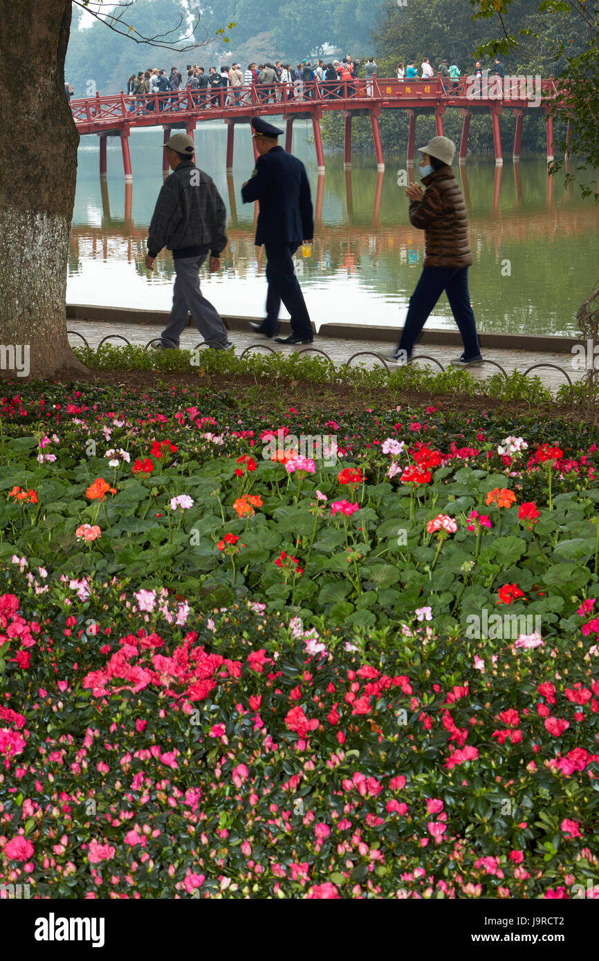 Blumen, Touristen auf die Huc Brücke und Hoan-Kiem-See, Hanoi, Vietnam Stockfoto