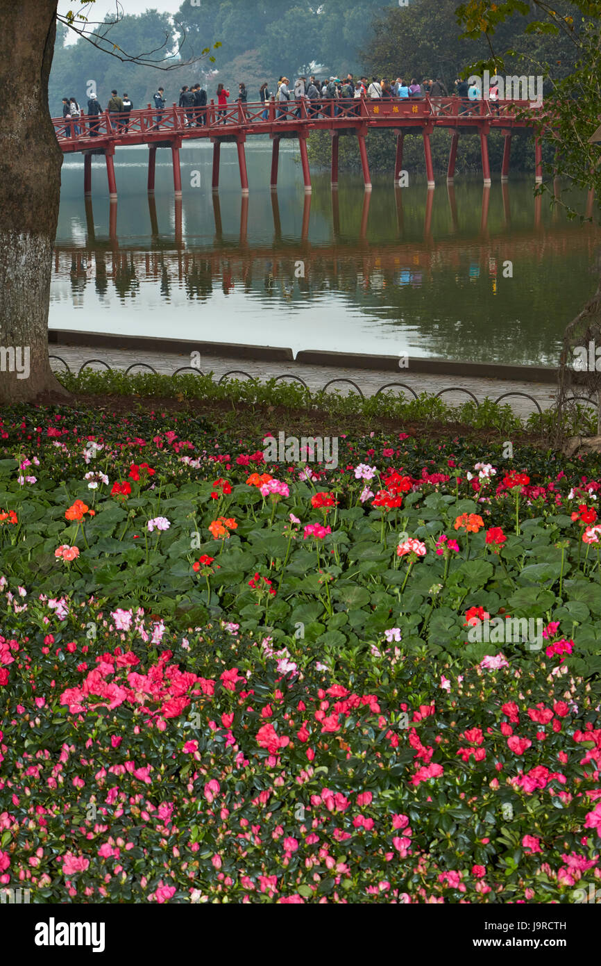 Blumen, Touristen auf die Huc Brücke und Hoan-Kiem-See, Hanoi, Vietnam Stockfoto