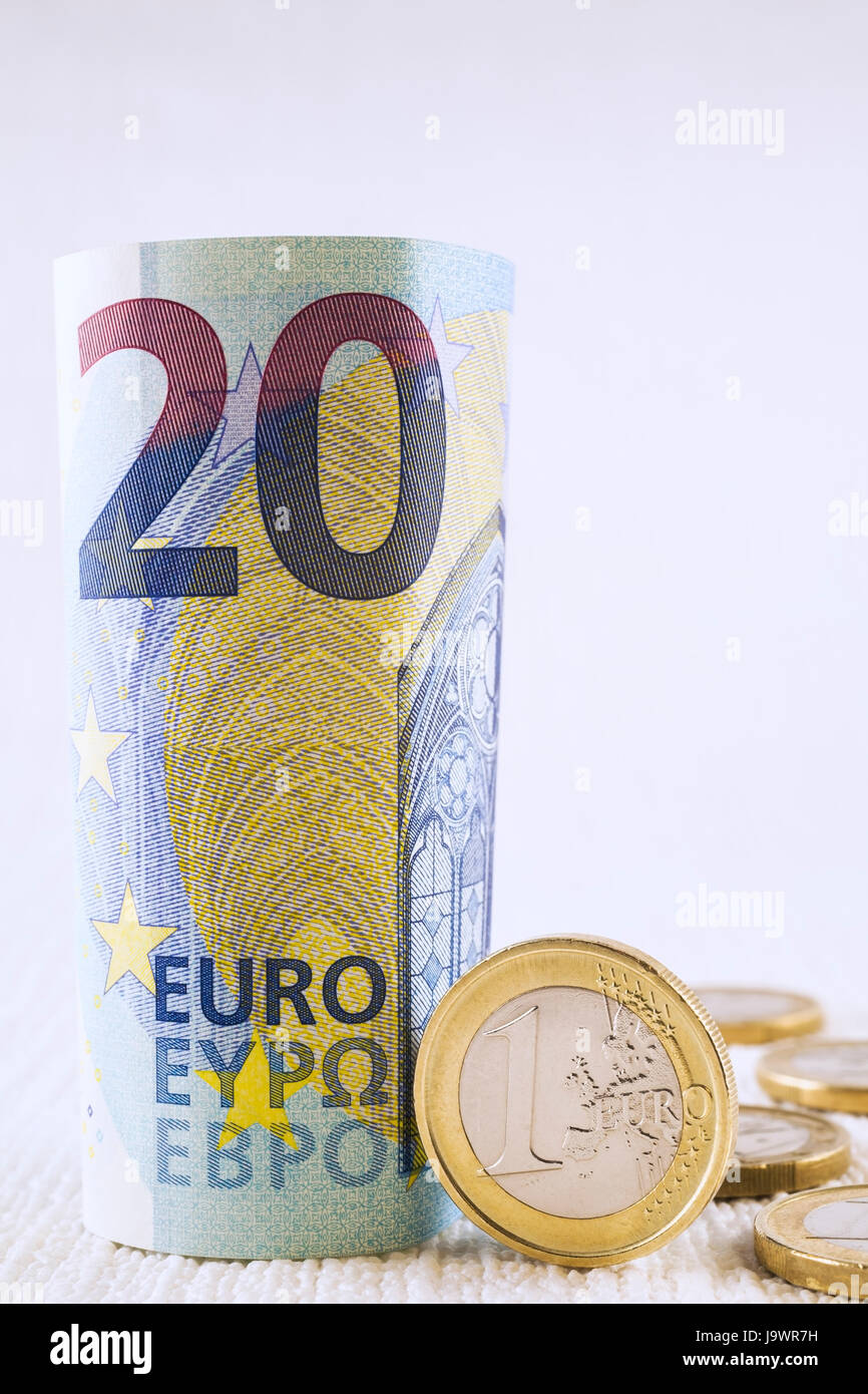 Rollte aufrecht 20 Euro-Banknote mit ein-Euro-Münze Stockfoto