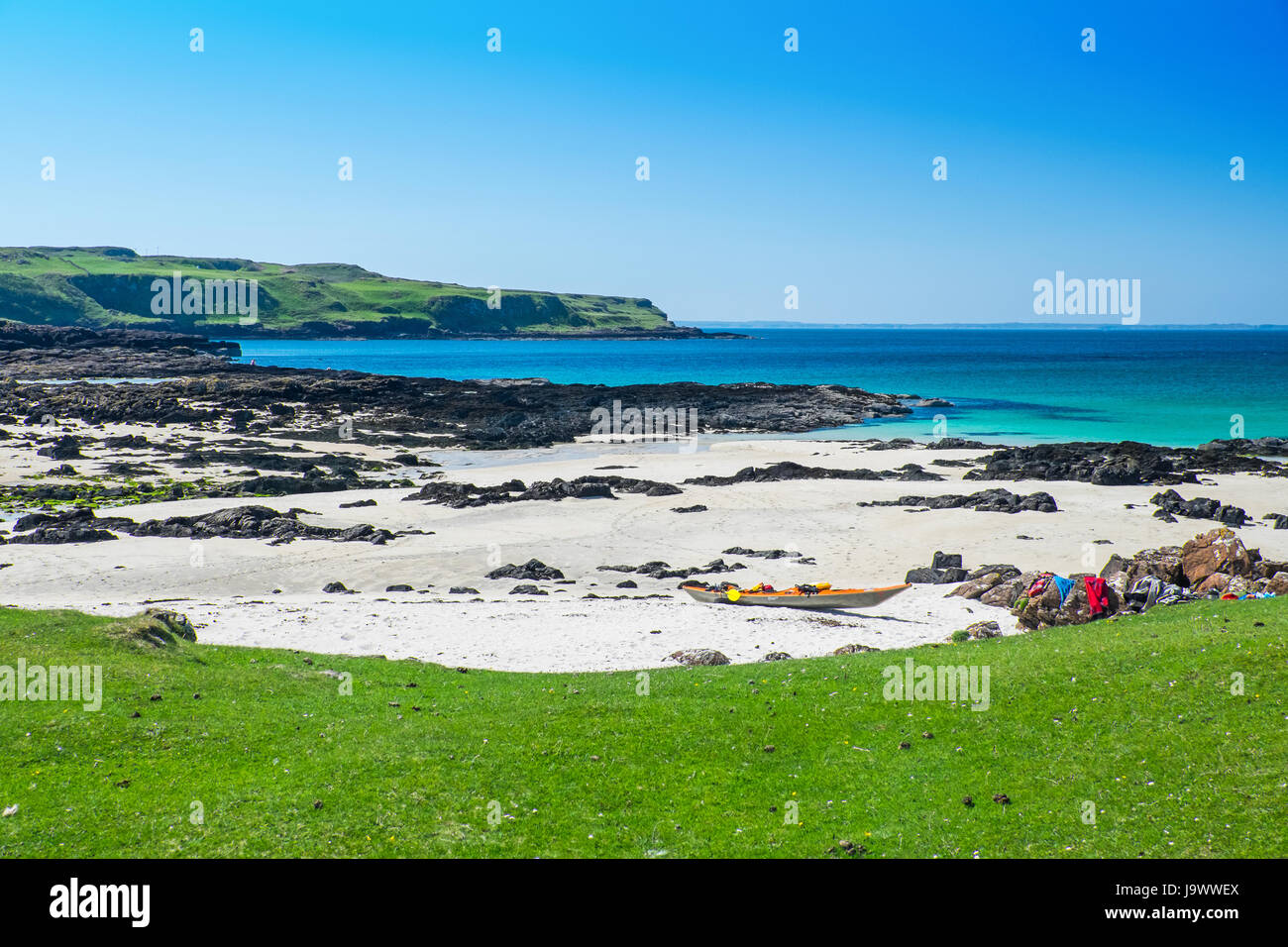 Kristallklares Wasser und weißer Sand bei Langamull Strand an der Nordküste von Mull in der schottischen Hebriden, mit einem Kajak auf den Strand Stockfoto