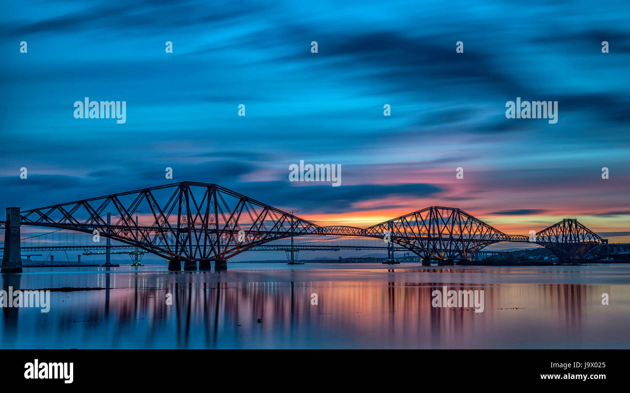 vierte Schiene Brücke über den Firth of her, Edinburgh South Queensferry, mit einem atemberaubenden Sonnenuntergang für einen Hintergrund dieses Set aus mit Reflexionen. Stockfoto
