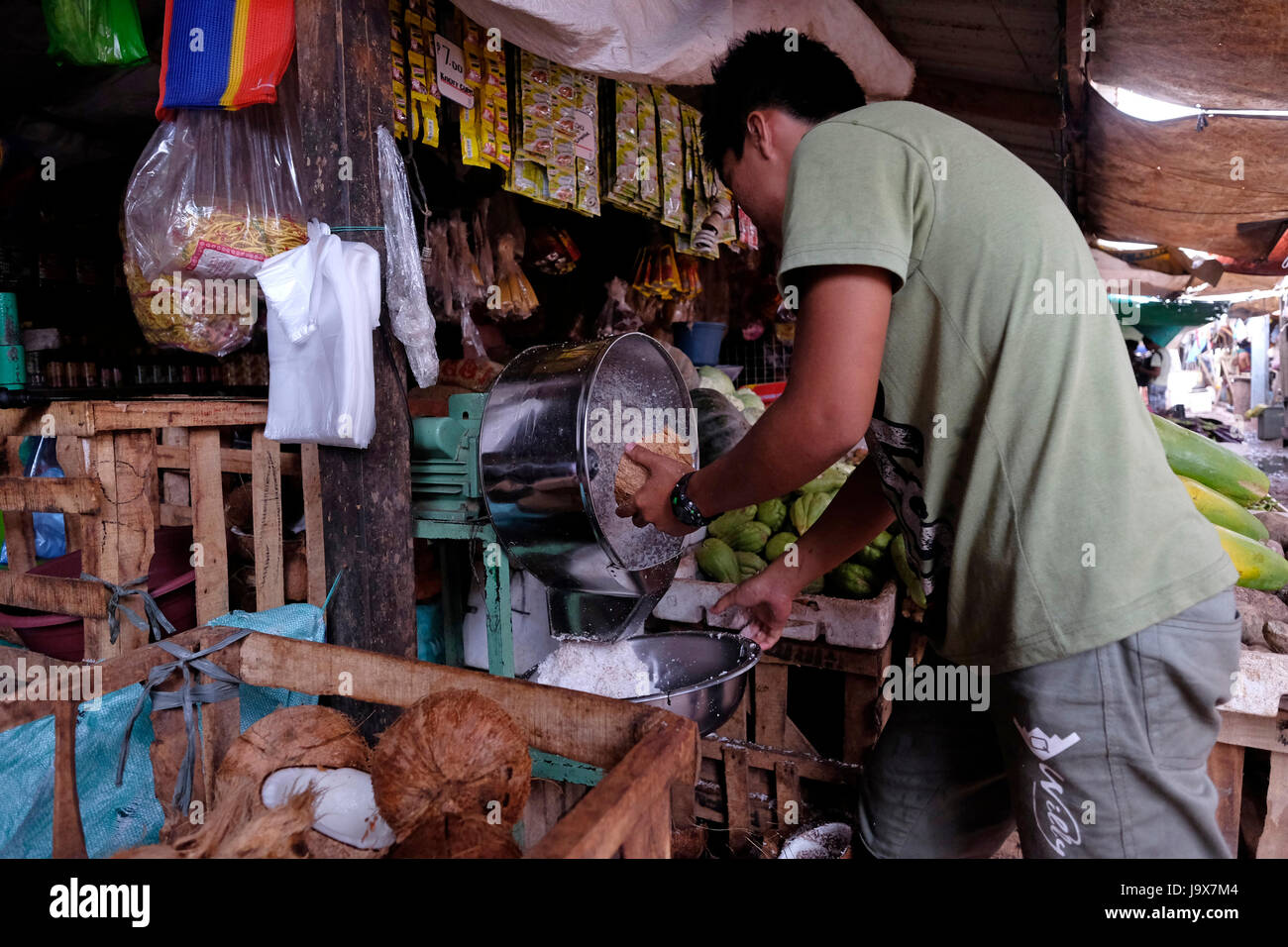 Ein Filipino Mann Gitter eine Kokosnuss mit einem Schredder-Maschine auf einem kleinen Wasser-Markt in der Stadt von Coron in Insel Busuanga in die Calamian Inseln im nördlichen Palawan auf den Philippinen Stockfoto