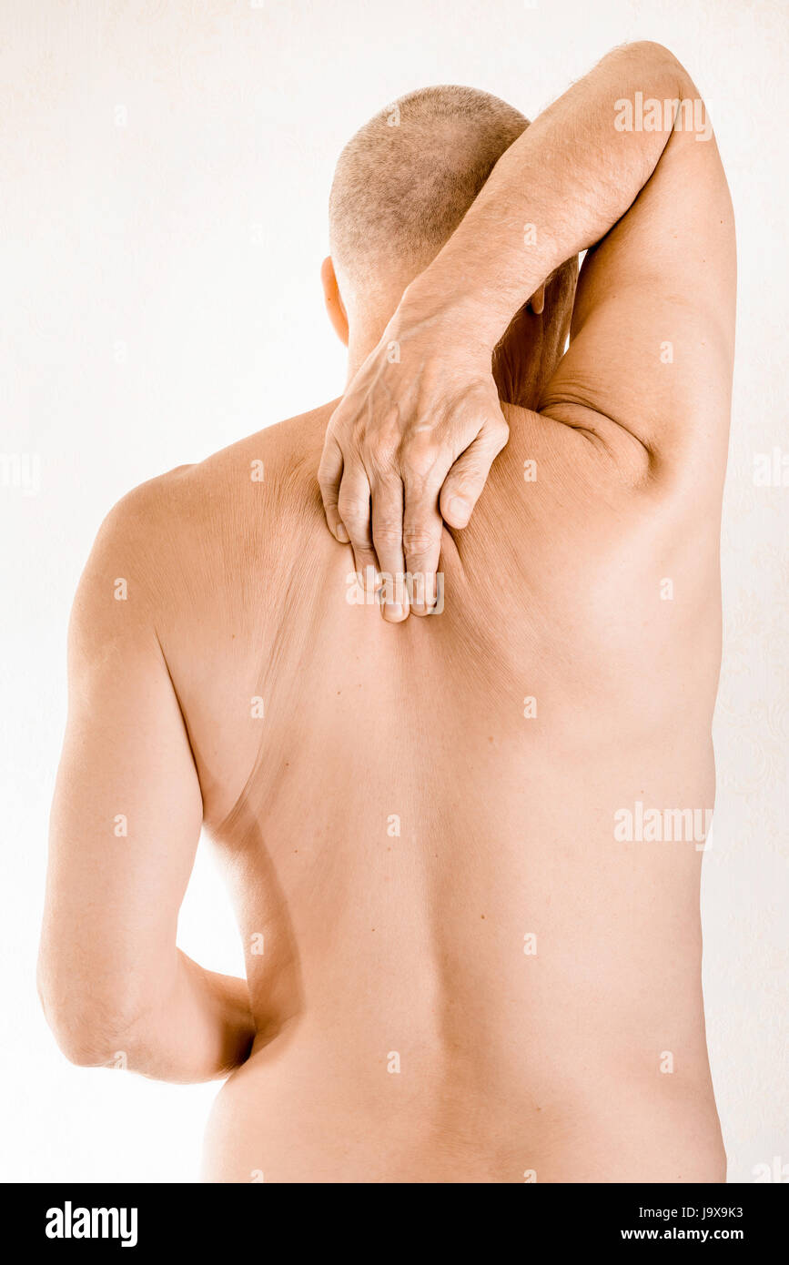 Mann massiert den oberen Rücken, zwischen den Schultern, weil ein Brustwirbel Schmerz durch eine Verschiebung von einem dorsalen Wirbel reiben auf einen Nerv Stockfoto