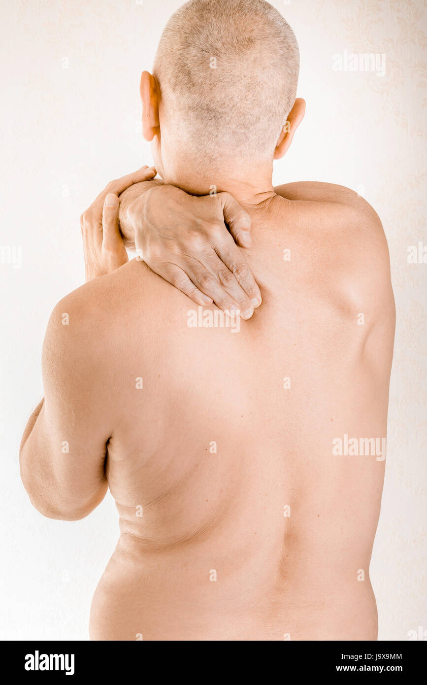 Mann massiert seine oberen Rücken, den Trapezius Muskel, wegen einem Brustwirbel Schmerzen durch eine Verschiebung von einem dorsalen Wirbel reiben auf einen Nerv Stockfoto