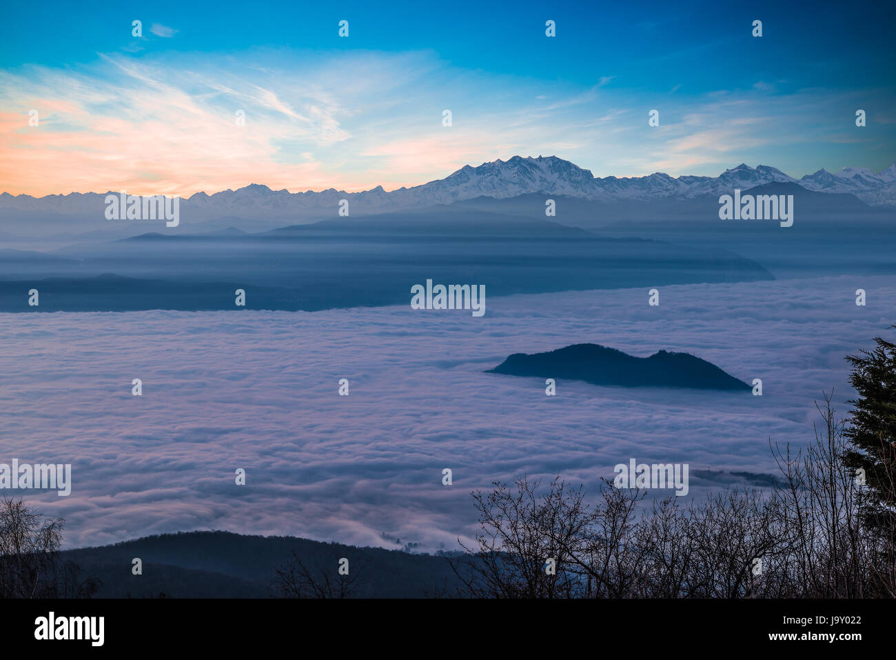 Alpenkette mit Monte Rosa ergibt sich aus einem Meer von Wolken bei Sonnenuntergang Stockfoto