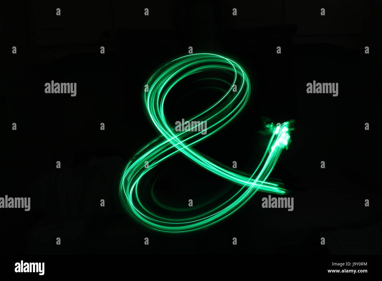 Grüne Lichterkette - kaufmännisches Symbol - Licht Malerei Fotografie vor schwarzem Hintergrund Stockfoto