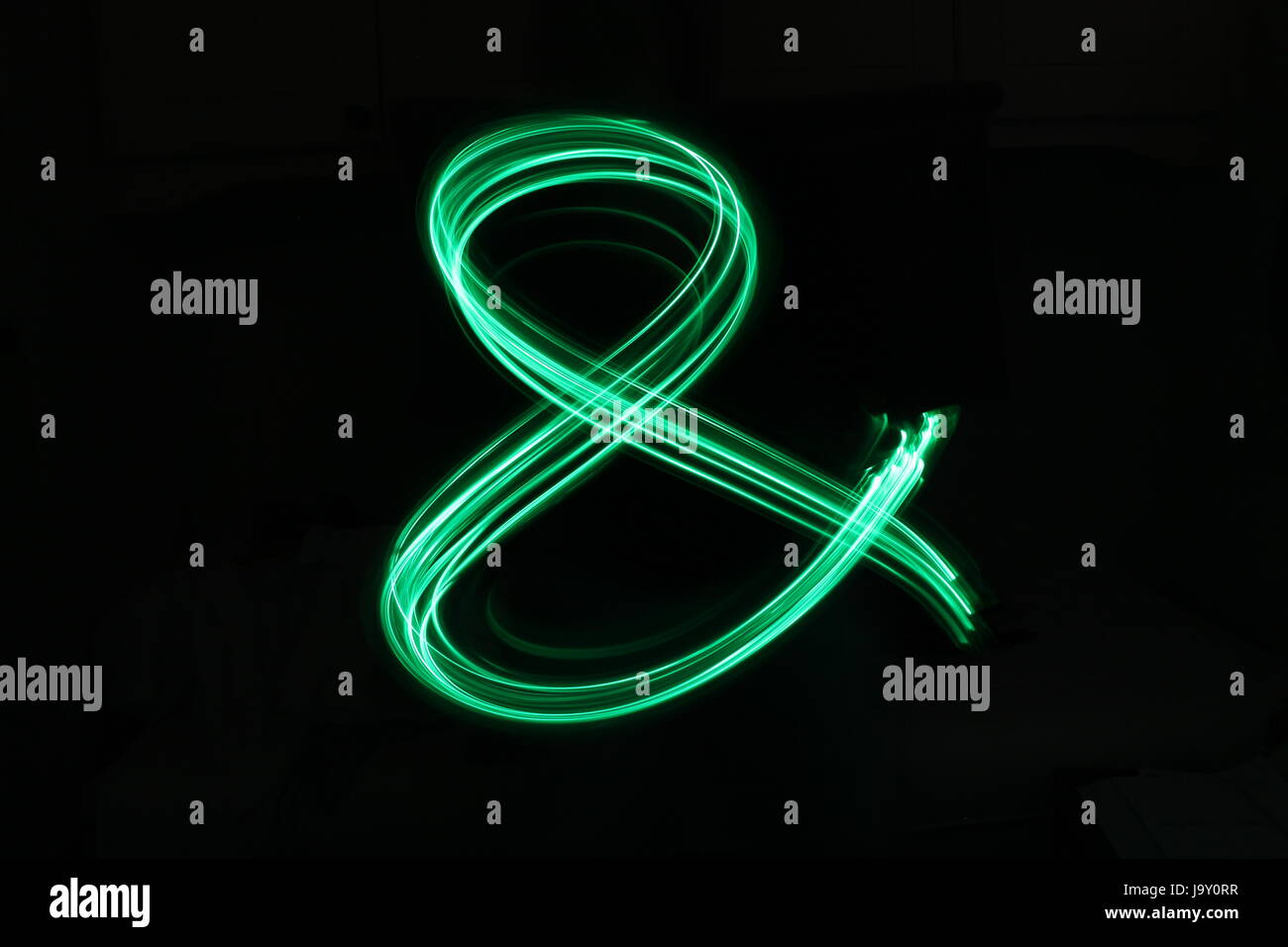 Grüne Lichterkette - kaufmännisches Symbol - Licht Malerei Fotografie vor schwarzem Hintergrund Stockfoto