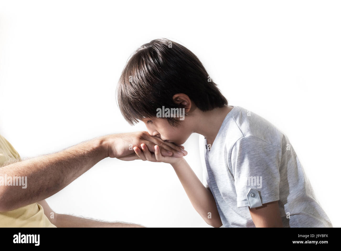 Kind küssen Elternteils Hand für traditionelle Akt der Respekt Stockfoto