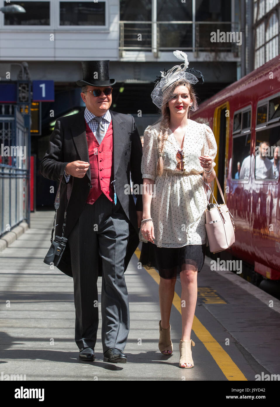 Racegoers bei Waterloo, bekleidet mit Zylinder und Frack und intelligente Damen Outfit Board den Zug bei Waterloo für das Epsom Derby Stockfoto