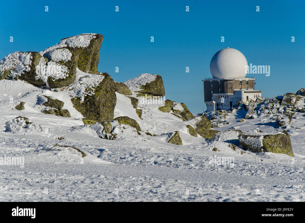 Alte Sternwarte in den Bergen gegen den tiefblauen Himmel und die Felsen, mit Schnee bedeckt Stockfoto