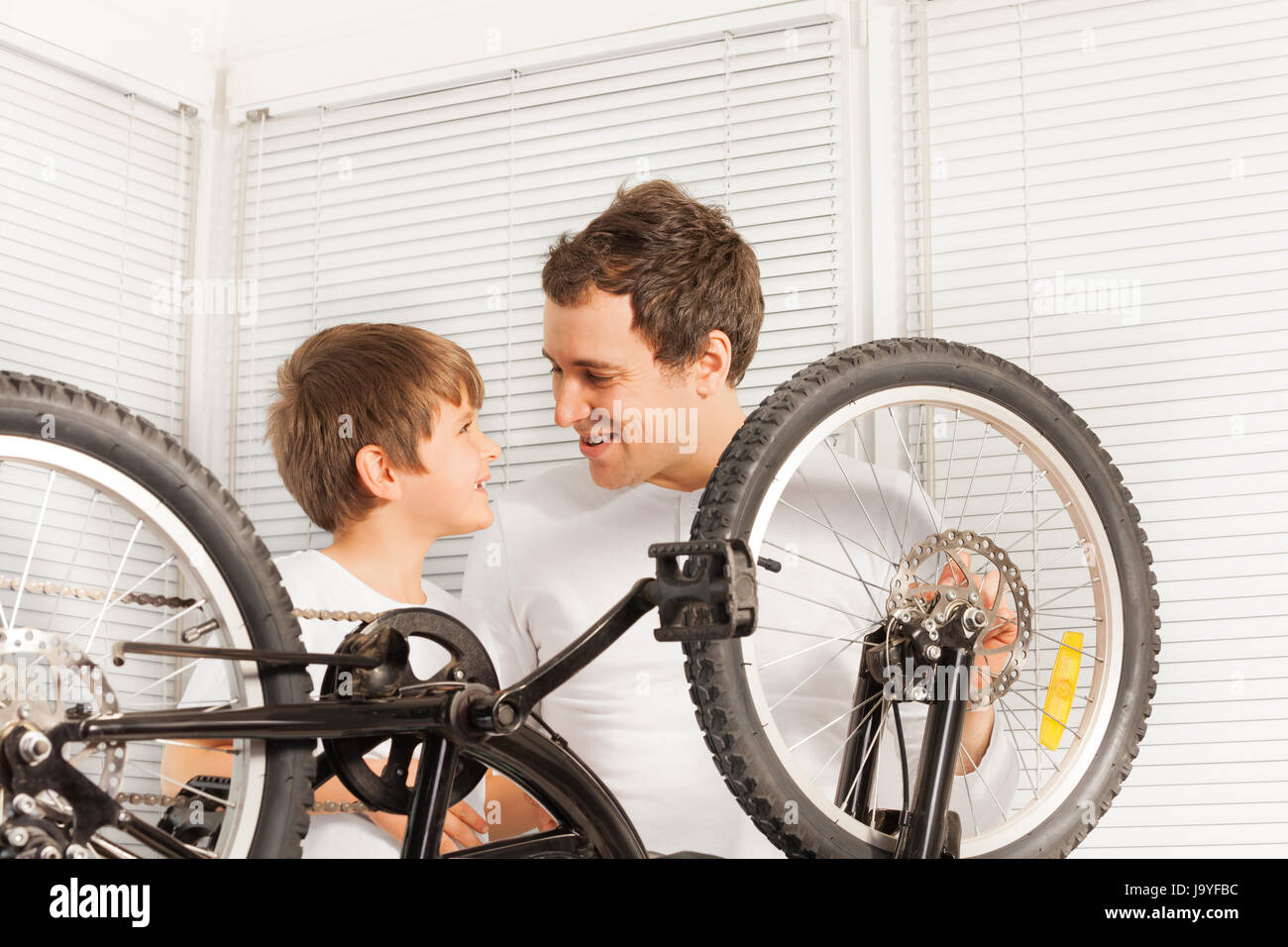 Vater und Sohn gemeinsam nach Befestigung Fahrrad Lächeln Stockfoto