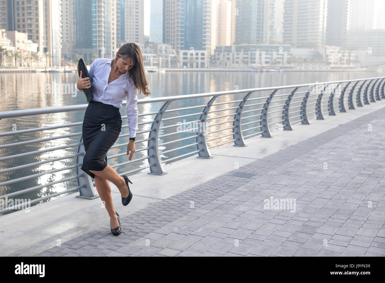 Professionelle Business-Frau überprüfen ihre high Heels auf einem Holzsteg  Stockfotografie - Alamy