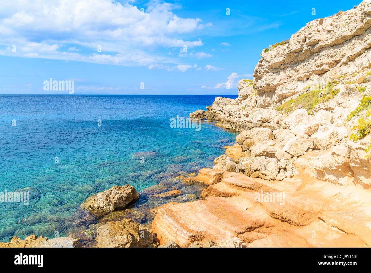 Felsen am Ufer und azurblauen Meerwasser in der Bucht von Kokkari an sonnigen Sommertag, Insel Samos, Griechenland Stockfoto