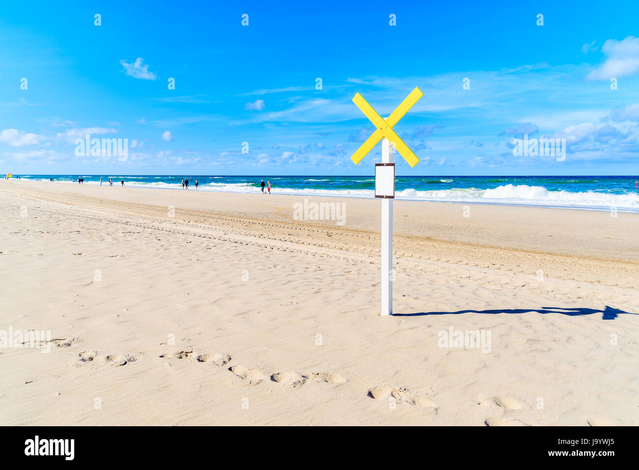 Holzstab mit gelben Kreuz unterzeichnen am Strand von Kampen an sonnigen Sommertag, Insel Sylt, Nordsee, Deutschland Stockfoto