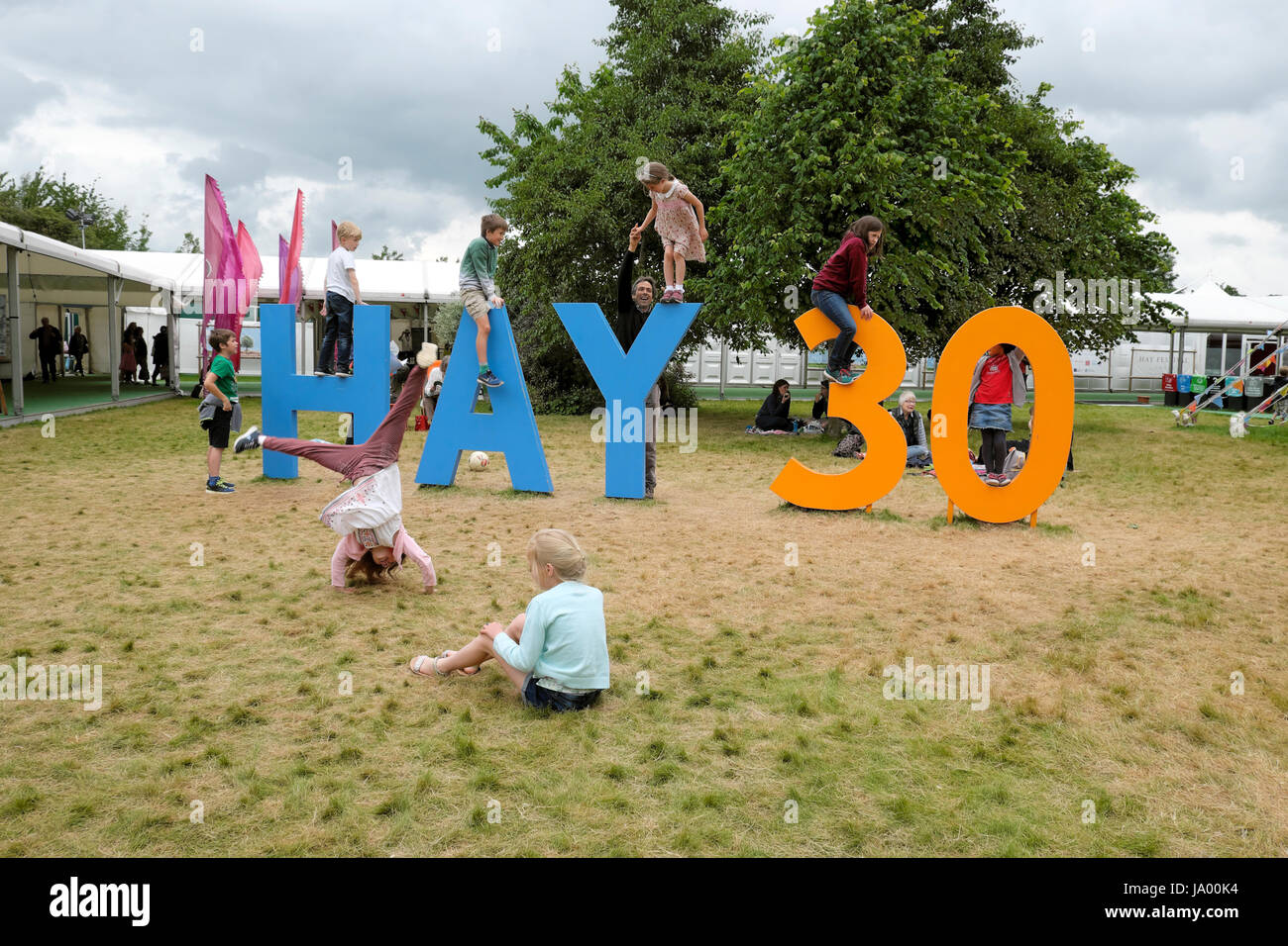 Kinder spielen im freien Klettern auf das Heu 30 Zeichen feiert das 30. Jahr der Hay Festival, Hay-on-Wye, Wales UK KATHY DEWITT Stockfoto