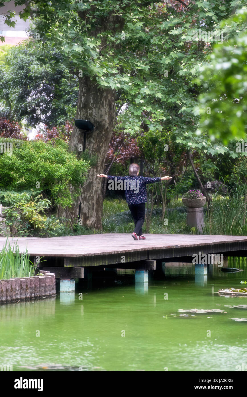 Ältere Frau macht Tai Chi im Jing'an Park, Shanghai, China Stockfoto
