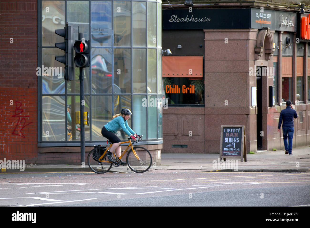 Frau Radfahrer an der belebten Charing Cross Ampel Glasgow Stockfoto