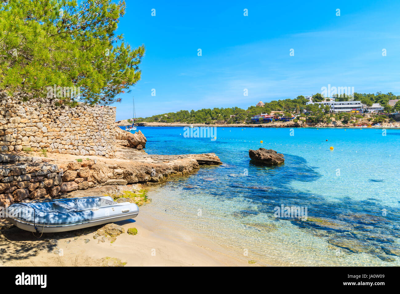 Jolle auf idyllischen Cala Portinatx Strand mit flachem kristallklarem Meerwasser, Insel Ibiza, Spanien Stockfoto