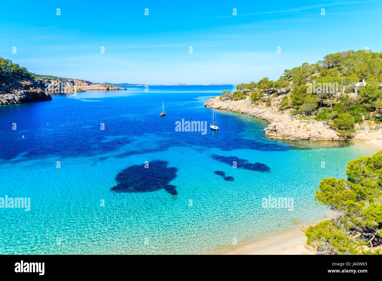 Blick auf den schönen Strand in Cala Salada Bucht berühmt für seine Azure kristallklares Meerwasser, Insel Ibiza, Spanien Stockfoto