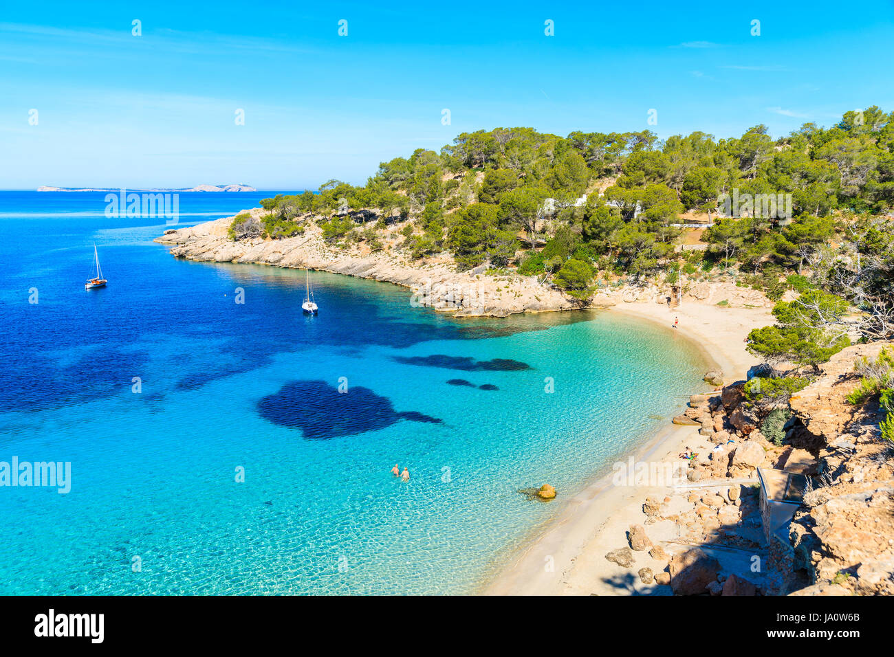 Blick auf den schönen Strand in Cala Salada Bucht berühmt für seine Azure kristallklares Meerwasser, Insel Ibiza, Spanien Stockfoto