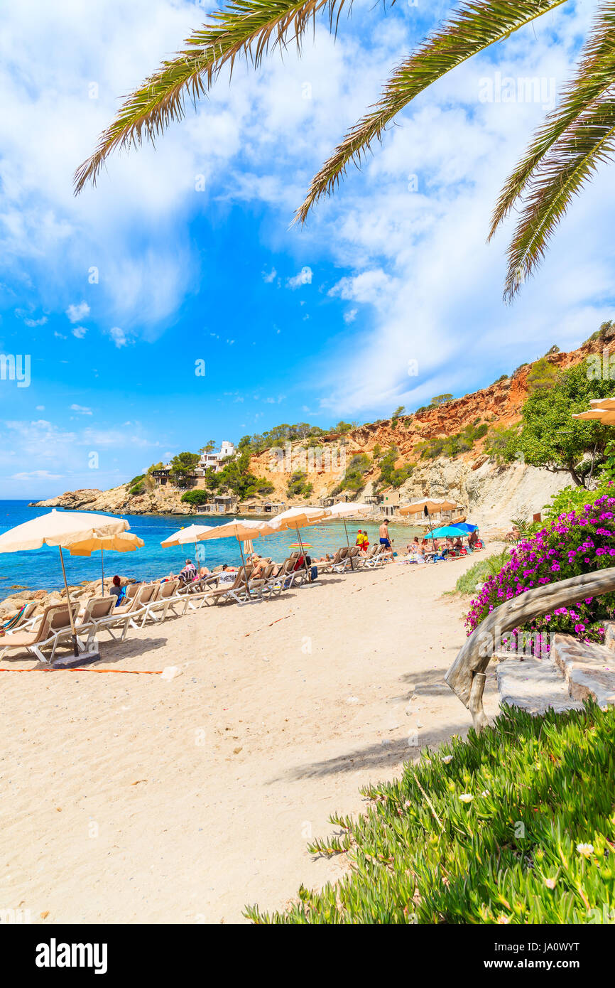 Insel IBIZA, Spanien - 18. Mai 2017: Blick auf den idyllischen Strand von Cala d ' Hort Wih Palme Blätter im Vordergrund, Insel Ibiza, Spanien. Stockfoto