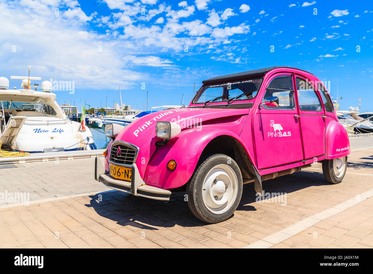 Hafen von SANTA EULARIA, IBIZA Insel - 18. Mai 2017: klassische alte Citroen 2CV in rosa Farbe Werbeagentur Charter Segelboote in Santa Eularia Stockfoto