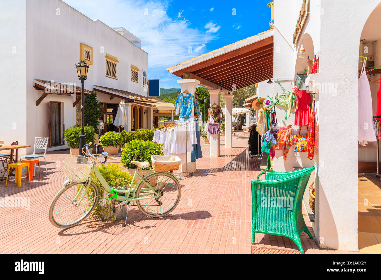 Grüne klassische Fahrrad dekoriert mit Frühlingsblumen auf Platz mit Shopes in Sant Carles de Peralta Dorf, Insel Ibiza, Spanien Stockfoto