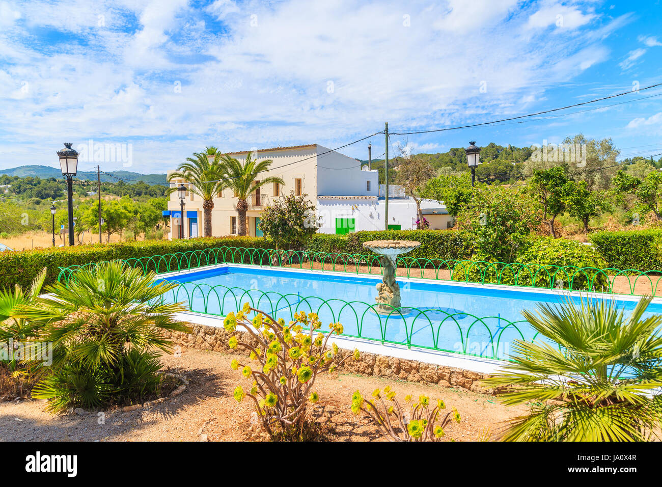 Wasser-Brunnen und tropischen Pflanzen im Park in Sant Carles de Peralta Dorf, Insel Ibiza, Spanien. Stockfoto
