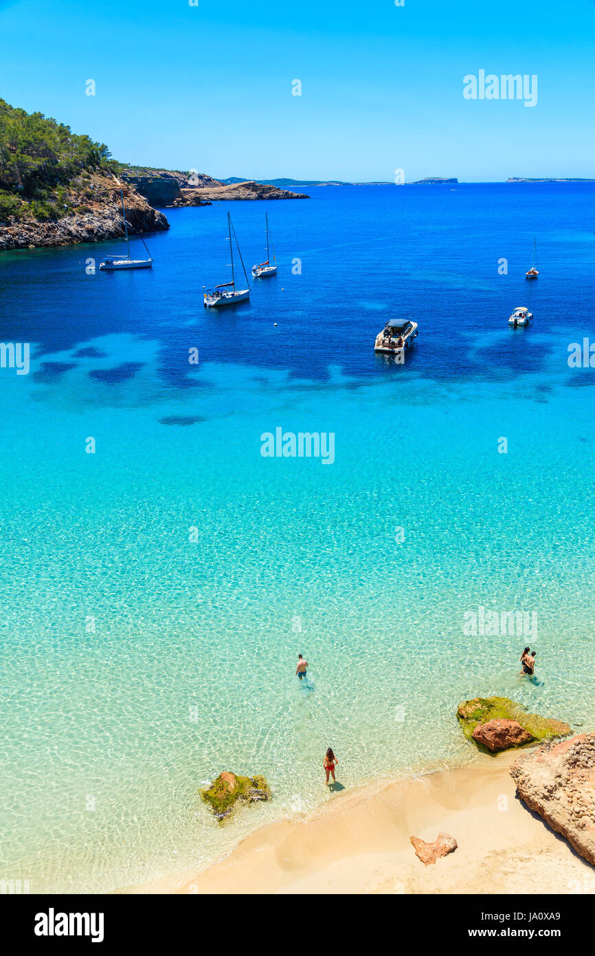 Nicht identifizierte zwei junge Paare am Strand in Cala Salada Bucht berühmt für seine Azure kristallklares Meerwasser, Insel Ibiza, Spanien Stockfoto