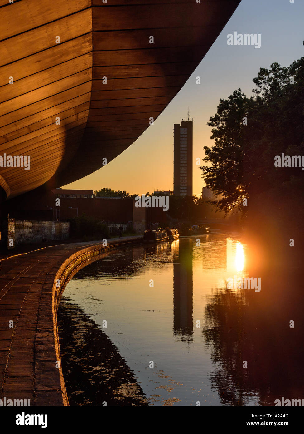 London, England - 19. Juli 2016: The Trellick Tower Wohnblocks und Westway Straßenüberführung in den Gewässern des Grand Union Canal bei Sonne spiegeln Stockfoto